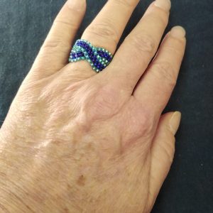 A handcrafted ring featuring Czech glass beads in dark and light blues. Measuring approximately ring size 6.5-7cm circumference.
