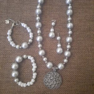 20240115_102504 White Flower Pendant Necklace Set - Elegant jewelry ensemble with metal pendant and white beads.