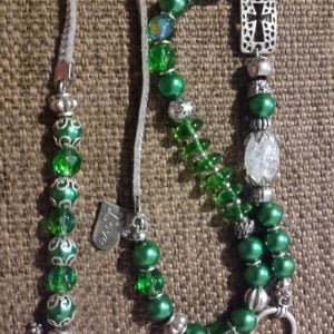 Emerald Wrap Bracelet - A collection of various round, flat, and white crystal beads with silver dividers and charms.