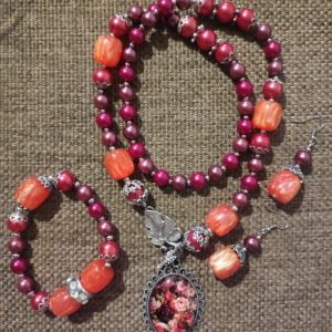 Flower Necklace Set - Handcrafted by RSart in South Africa, featuring maroon and cherry pink glass beads, silver accents, cylinder orange marble beads, flower pendant, and crystal slider bracelet detail.