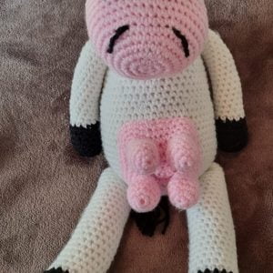 Front facing view of a 30cm crocheted cow soft toy Miss Daisy.