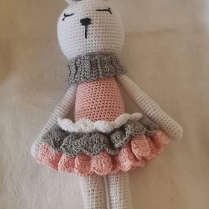 Handmade crocheted bunny newborn set featuring a white bunny with a pink and grey dress, grey collar, and bow. Includes Bunny Soft Toy, Teether, Stick Rattle, and Dummy Clip.