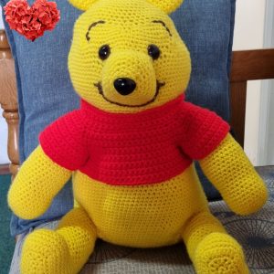 Crocheted Winnie the Pooh toy character holding his tummy, smiling, approximately 40cm tall, handcrafted by Pippie Langbeen in South Africa.