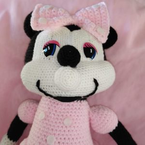 A 45cm tall crocheted Minnie Mouse soft toy smiling and wearing a pink bow matching her pink dress.